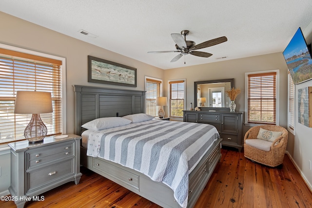 bedroom featuring dark wood-style floors, a textured ceiling, and visible vents