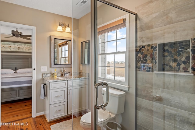 ensuite bathroom with a shower stall, vanity, wood finished floors, and ensuite bathroom