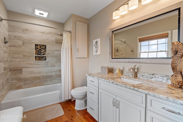 full bathroom with vanity, shower / tub combo, wood finished floors, and toilet