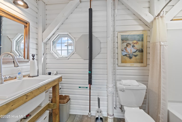 full bath with wood walls, vanity, toilet, and wood finished floors