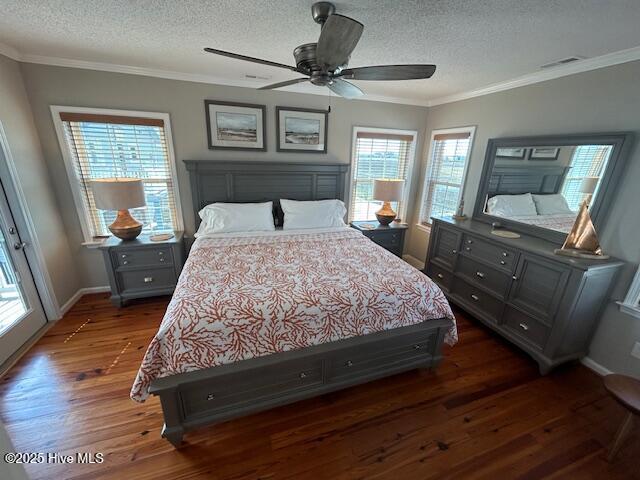 bedroom with a textured ceiling, ornamental molding, wood finished floors, and baseboards