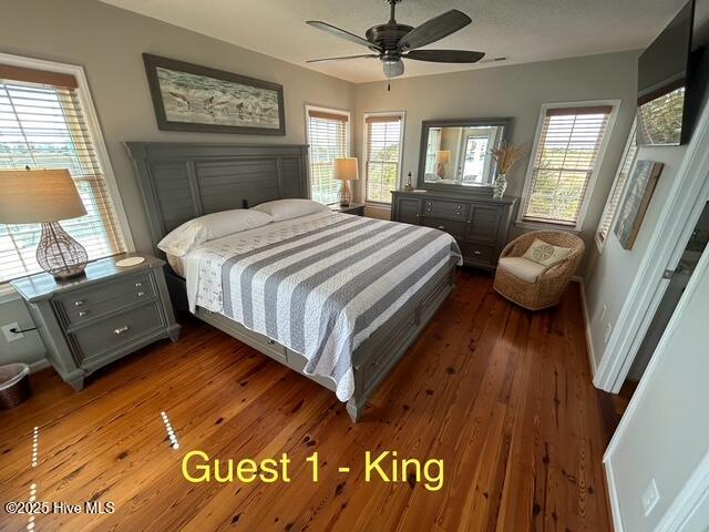 bedroom with wood-type flooring, baseboards, and ceiling fan