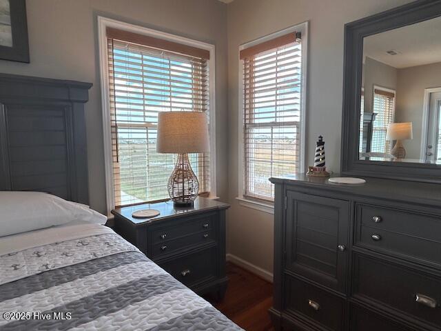 bedroom with dark wood-type flooring and baseboards