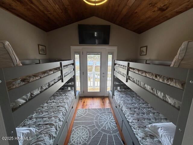 bedroom with lofted ceiling, wood ceiling, and wood finished floors