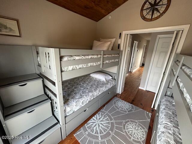 bedroom with lofted ceiling and wood finished floors