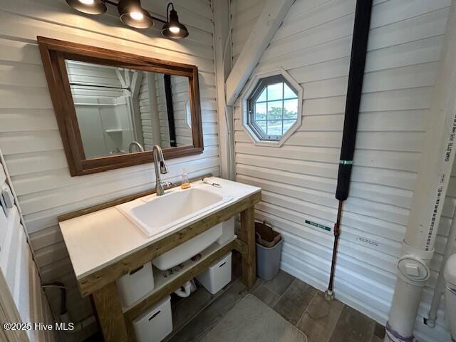 bathroom with wooden walls, vanity, toilet, and wood finished floors