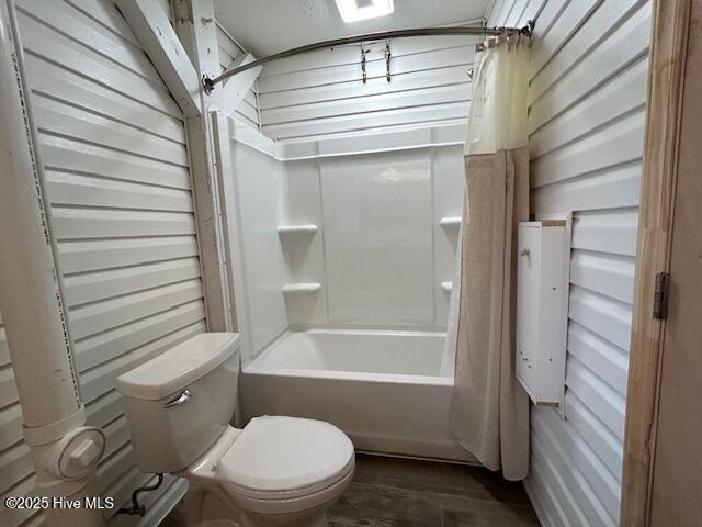 bathroom with shower / bath combo with shower curtain and toilet