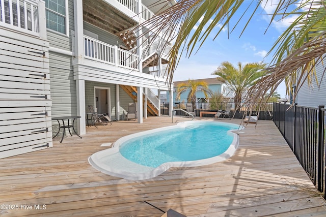 view of pool featuring a fenced in pool, a wooden deck, and stairs