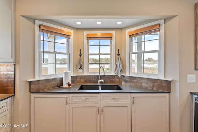 kitchen with dark countertops, a sink, and recessed lighting