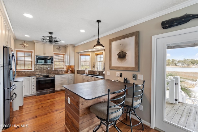 kitchen featuring dark countertops, tasteful backsplash, stainless steel appliances, and a wealth of natural light