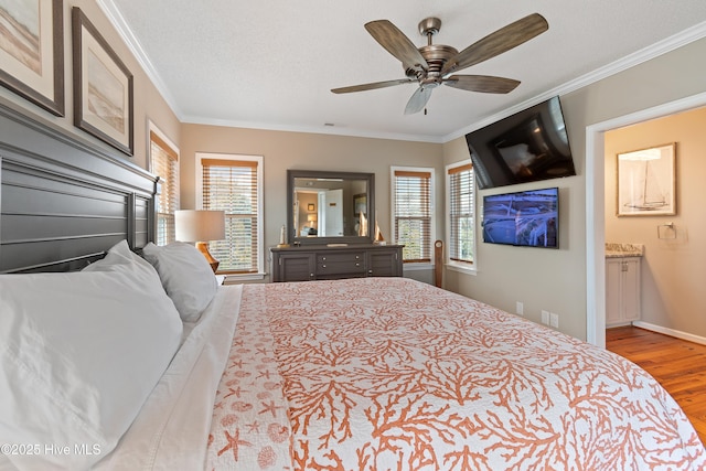 bedroom featuring ornamental molding, multiple windows, wood finished floors, and baseboards