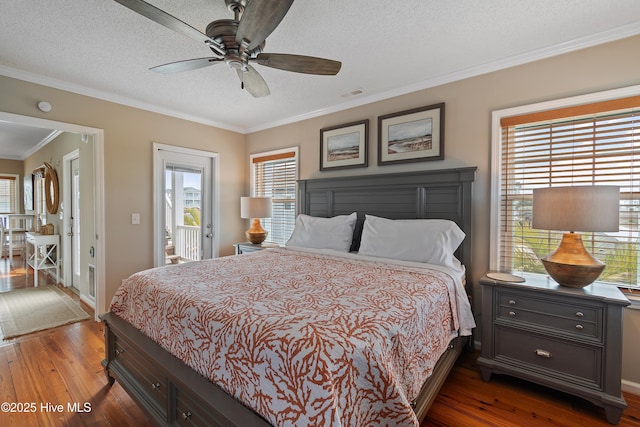 bedroom featuring visible vents, a textured ceiling, ornamental molding, and wood finished floors