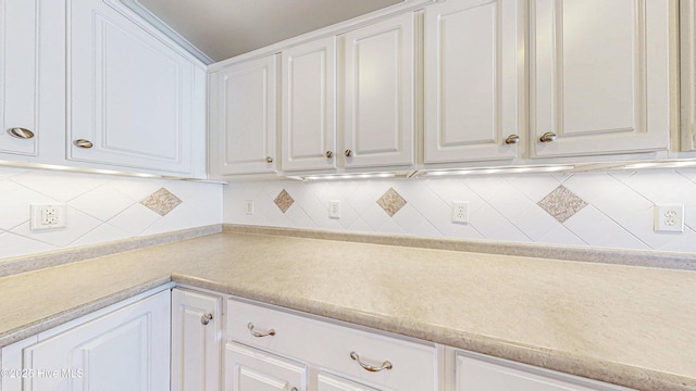 kitchen with light countertops, white cabinetry, and decorative backsplash