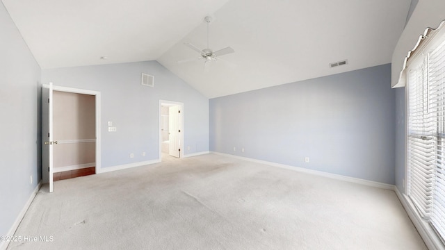 unfurnished bedroom featuring light colored carpet, visible vents, lofted ceiling, and baseboards