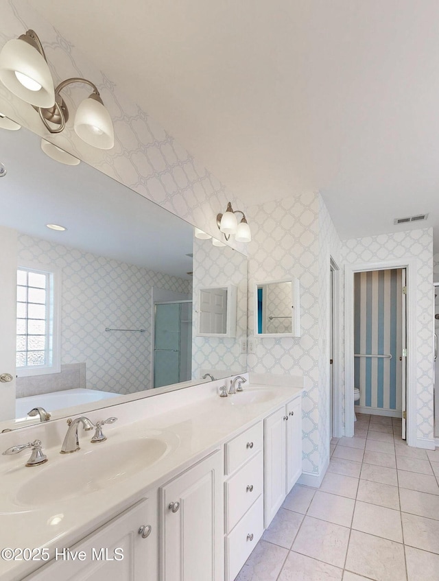 full bathroom with visible vents, a sink, a shower stall, tile patterned flooring, and wallpapered walls