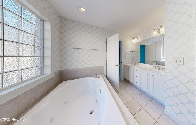 bathroom featuring double vanity, a sink, tile patterned flooring, a jetted tub, and wallpapered walls