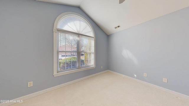 unfurnished room featuring lofted ceiling, baseboards, visible vents, and carpet flooring