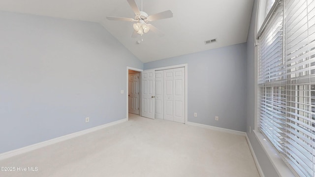 unfurnished bedroom featuring vaulted ceiling, multiple windows, carpet, and visible vents