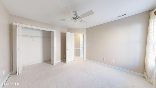 unfurnished bedroom featuring a closet, light colored carpet, visible vents, ceiling fan, and baseboards