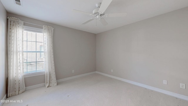 empty room featuring a ceiling fan, carpet, visible vents, and baseboards