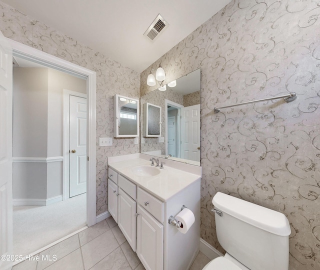 bathroom with wallpapered walls, baseboards, visible vents, toilet, and vanity