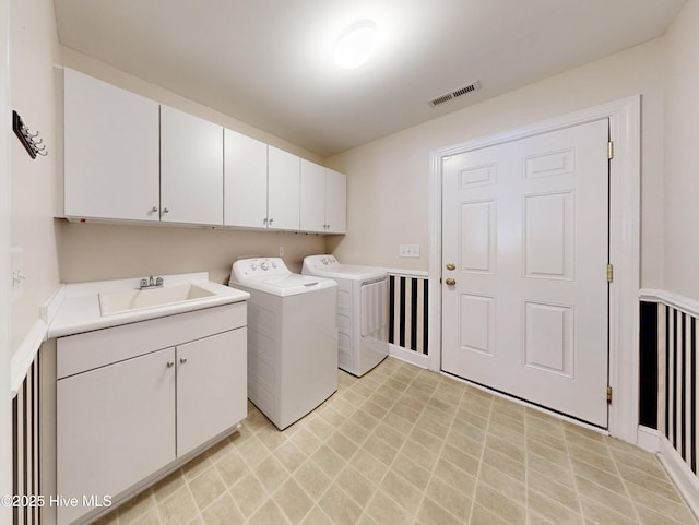 laundry room with visible vents, cabinet space, a sink, and separate washer and dryer