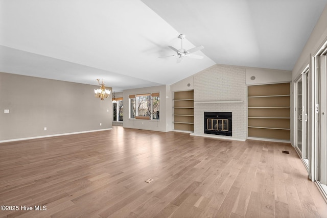 unfurnished living room with light wood-style floors, a fireplace, built in features, and vaulted ceiling