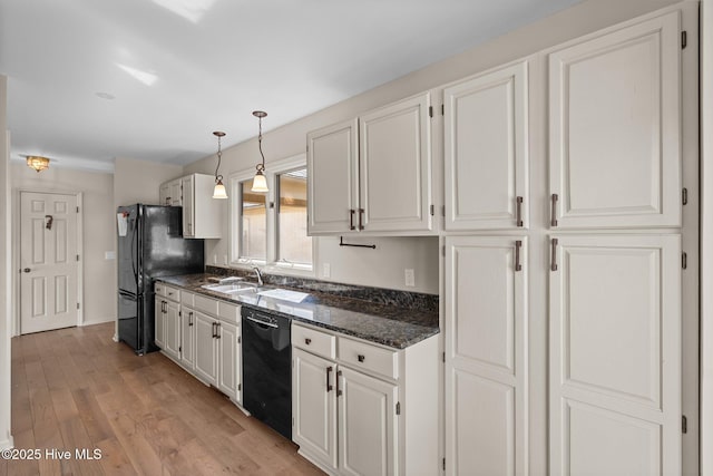 kitchen featuring light wood-style floors, white cabinets, a sink, and black appliances