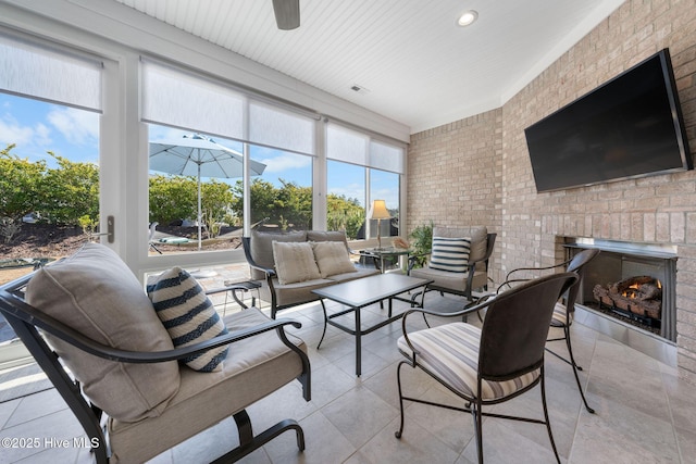 sunroom / solarium featuring visible vents, a fireplace, and ceiling fan