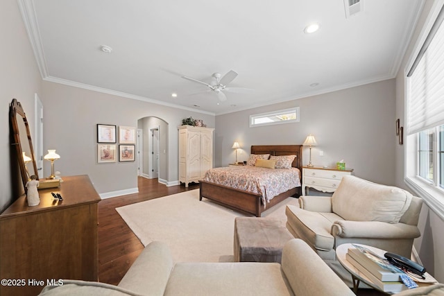 bedroom with dark wood-style floors, arched walkways, visible vents, ornamental molding, and baseboards