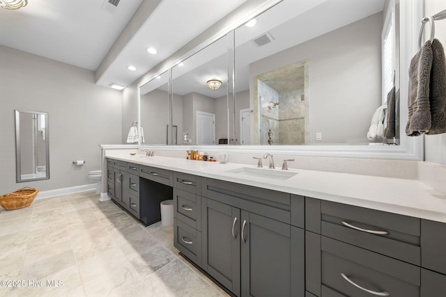 full bath with visible vents, tiled shower, a sink, and toilet