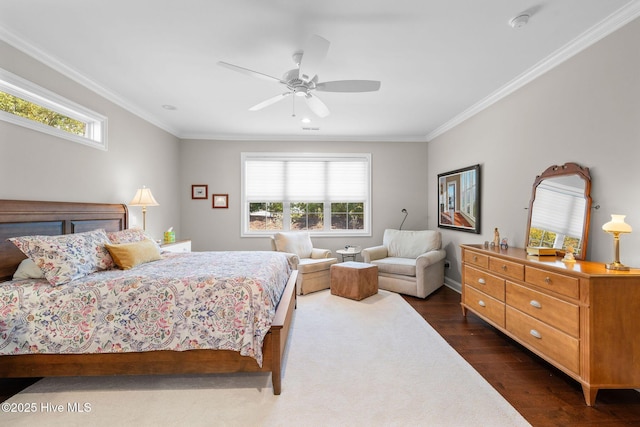 bedroom featuring dark wood-style floors, ornamental molding, and a ceiling fan