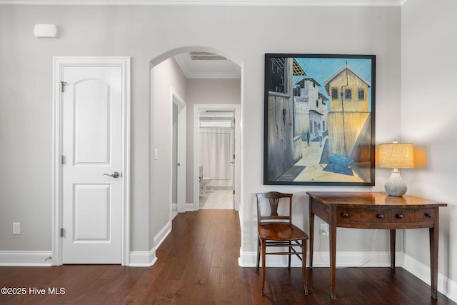 hall with arched walkways, hardwood / wood-style flooring, and baseboards