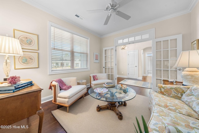 living area with arched walkways, visible vents, crown molding, and wood finished floors