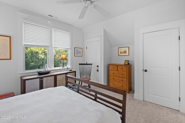 bedroom with a ceiling fan, visible vents, vaulted ceiling, and carpet flooring