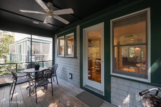 sunroom / solarium with a ceiling fan