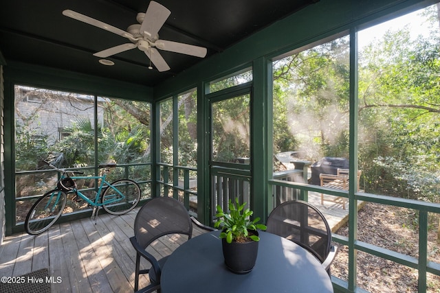 unfurnished sunroom featuring a ceiling fan