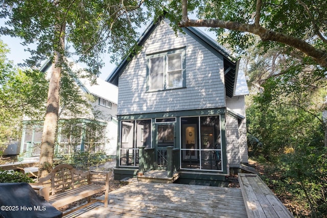 rear view of house with a sunroom and a deck