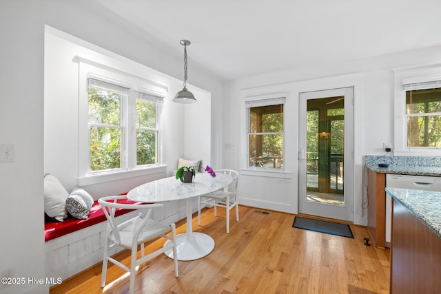 dining space featuring light wood-style floors, visible vents, and breakfast area