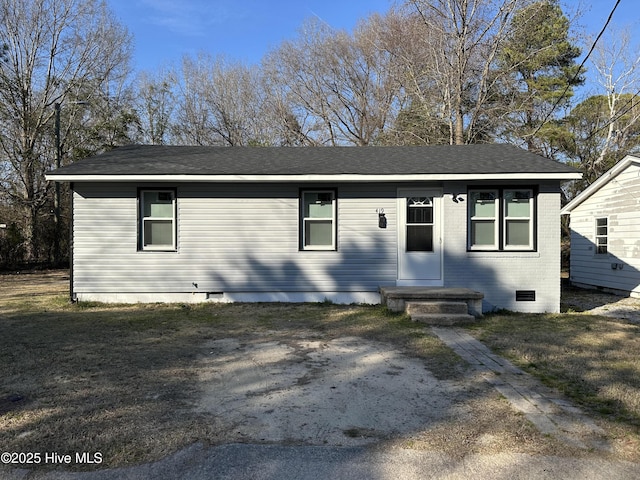 view of front of home with crawl space, a front yard, and brick siding