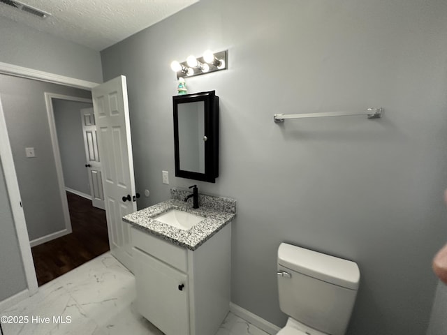 half bathroom with a textured ceiling, toilet, vanity, visible vents, and marble finish floor