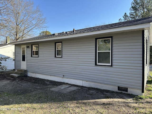 exterior space with a shingled roof, entry steps, and crawl space