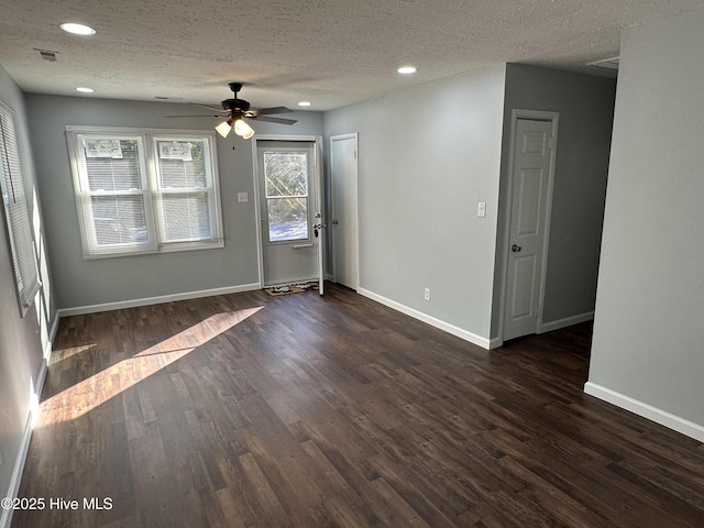 empty room with baseboards, dark wood-style flooring, and recessed lighting