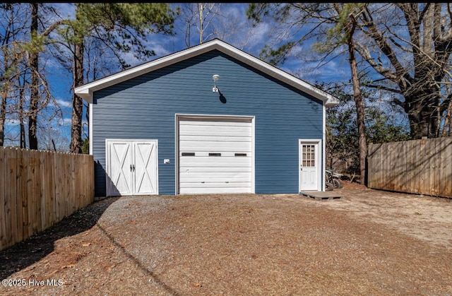 detached garage with driveway and fence