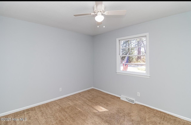 empty room featuring ceiling fan, a textured ceiling, visible vents, baseboards, and carpet