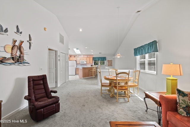 dining area with light carpet, high vaulted ceiling, visible vents, and baseboards