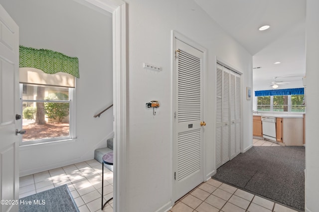 hallway featuring light tile patterned floors, baseboards, stairs, and recessed lighting