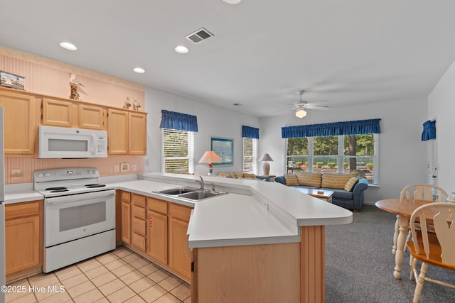 kitchen featuring white appliances, visible vents, open floor plan, a peninsula, and a sink