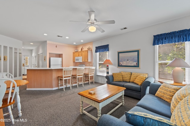 living area with recessed lighting, a healthy amount of sunlight, visible vents, and ceiling fan