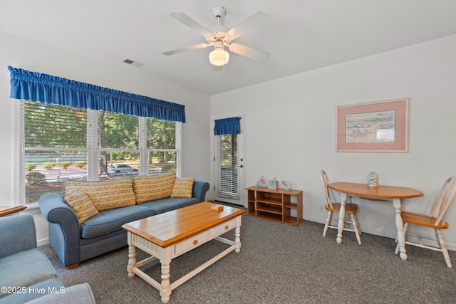 living room with carpet, visible vents, ceiling fan, and baseboards